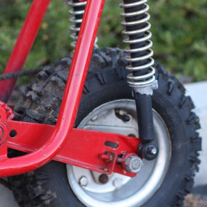 red minibike left side rear wheel and shocks